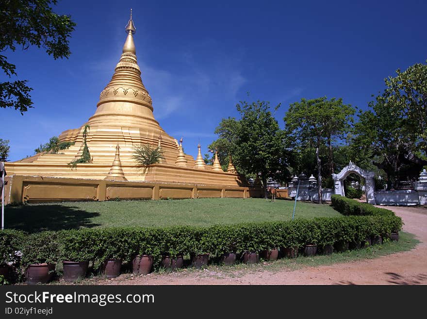 Mimetic Gold Pagoda with blue sky and green tree