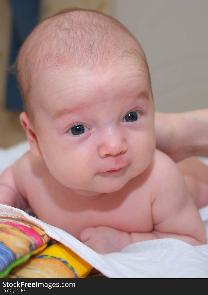 Photo of the beautiful baby lying on bed. Photo of the beautiful baby lying on bed