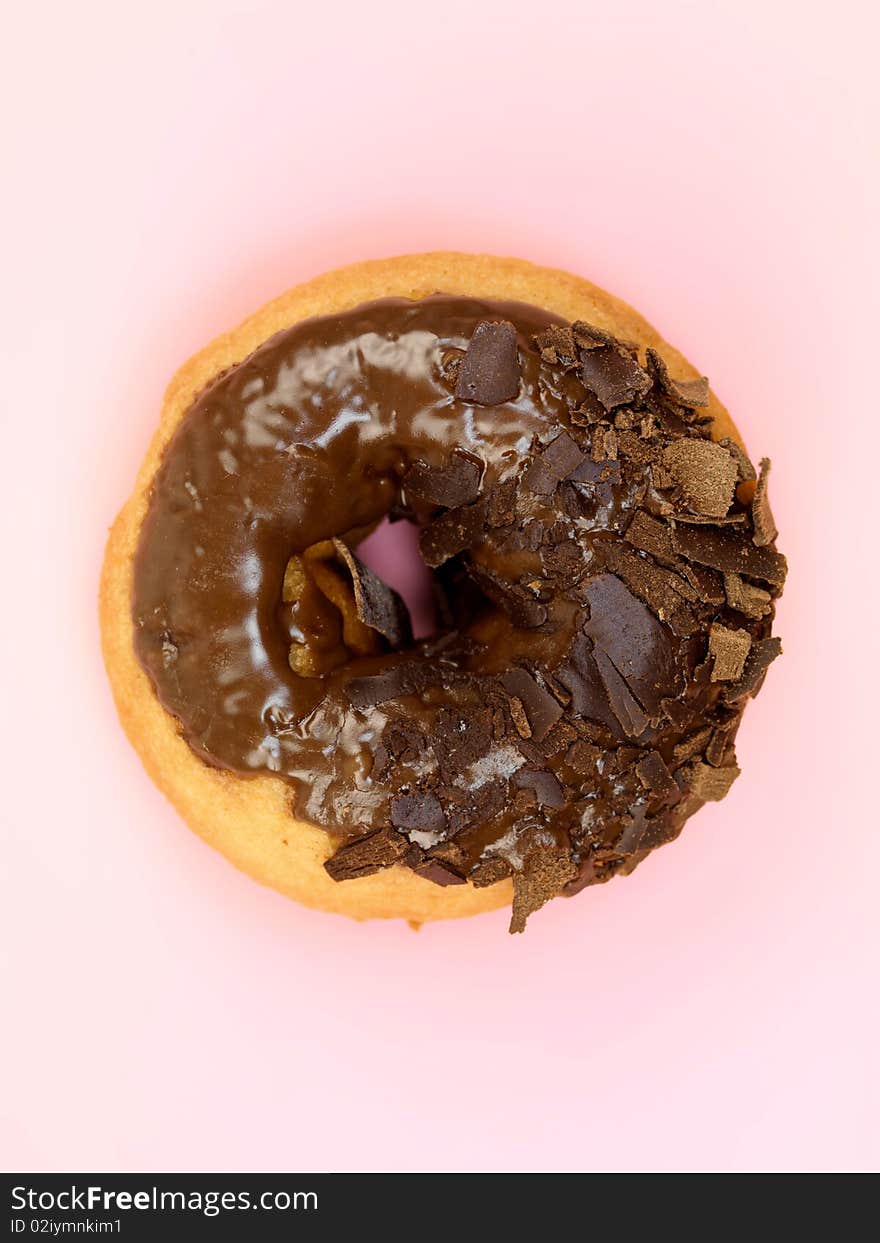 Chocolate donuts in a plate isolated against a pink background