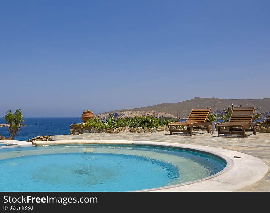 Sun Beds Around The Round Pool On The Sea