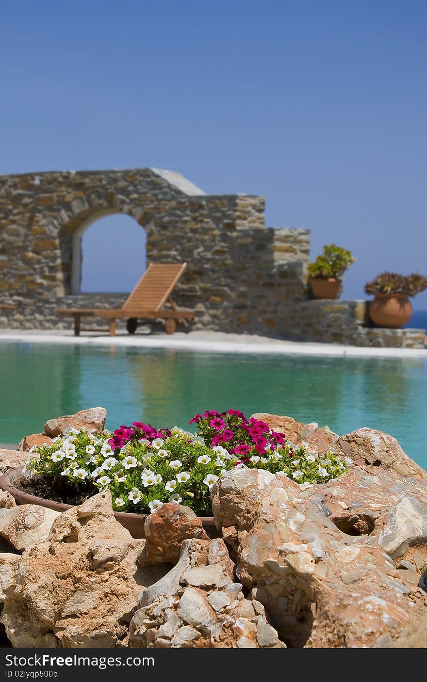 Stone flower beds around the pool with sun beds on Mykonos. Stone flower beds around the pool with sun beds on Mykonos