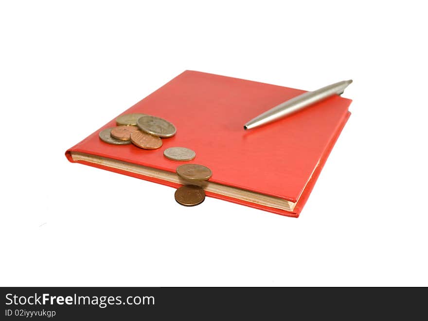 Red notebook and steel pen with coins isolated on white