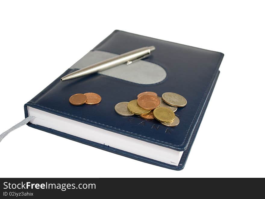 Notebook with coins and pen isolated on white