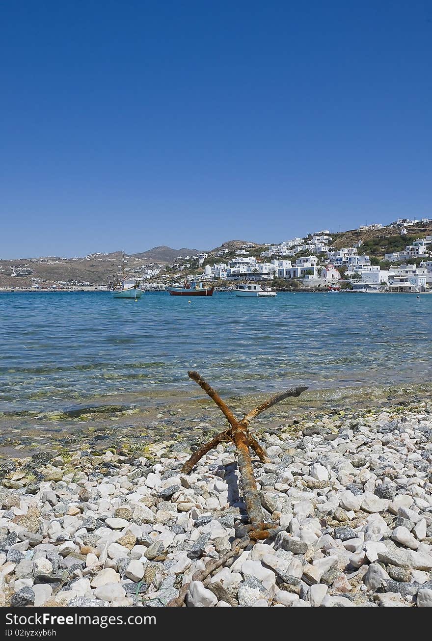 Old anchor on the shore of the bay of Mykonos