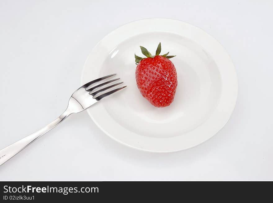 Strawberry and forks on the white Plates