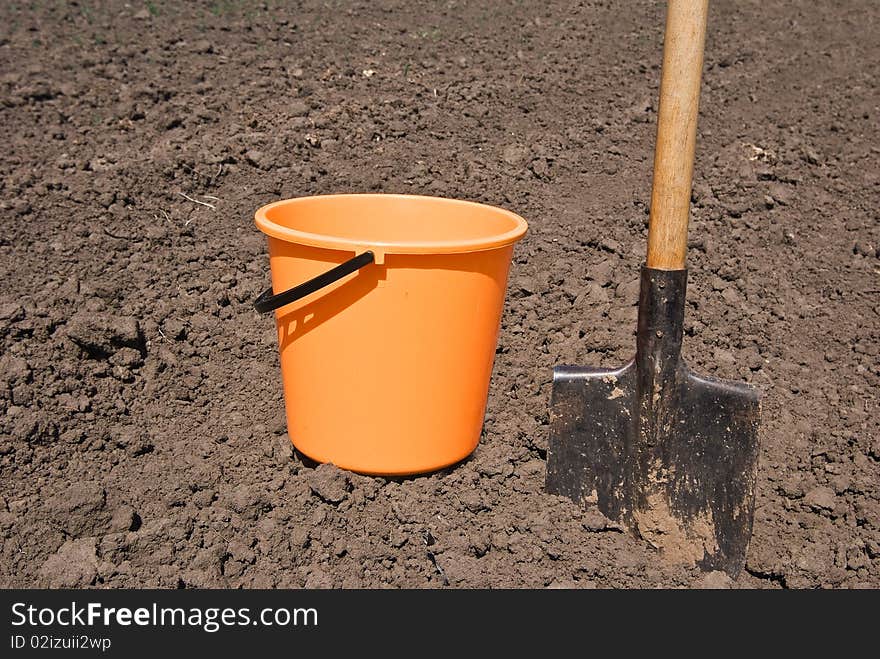 Orange bucket and shovel on a field