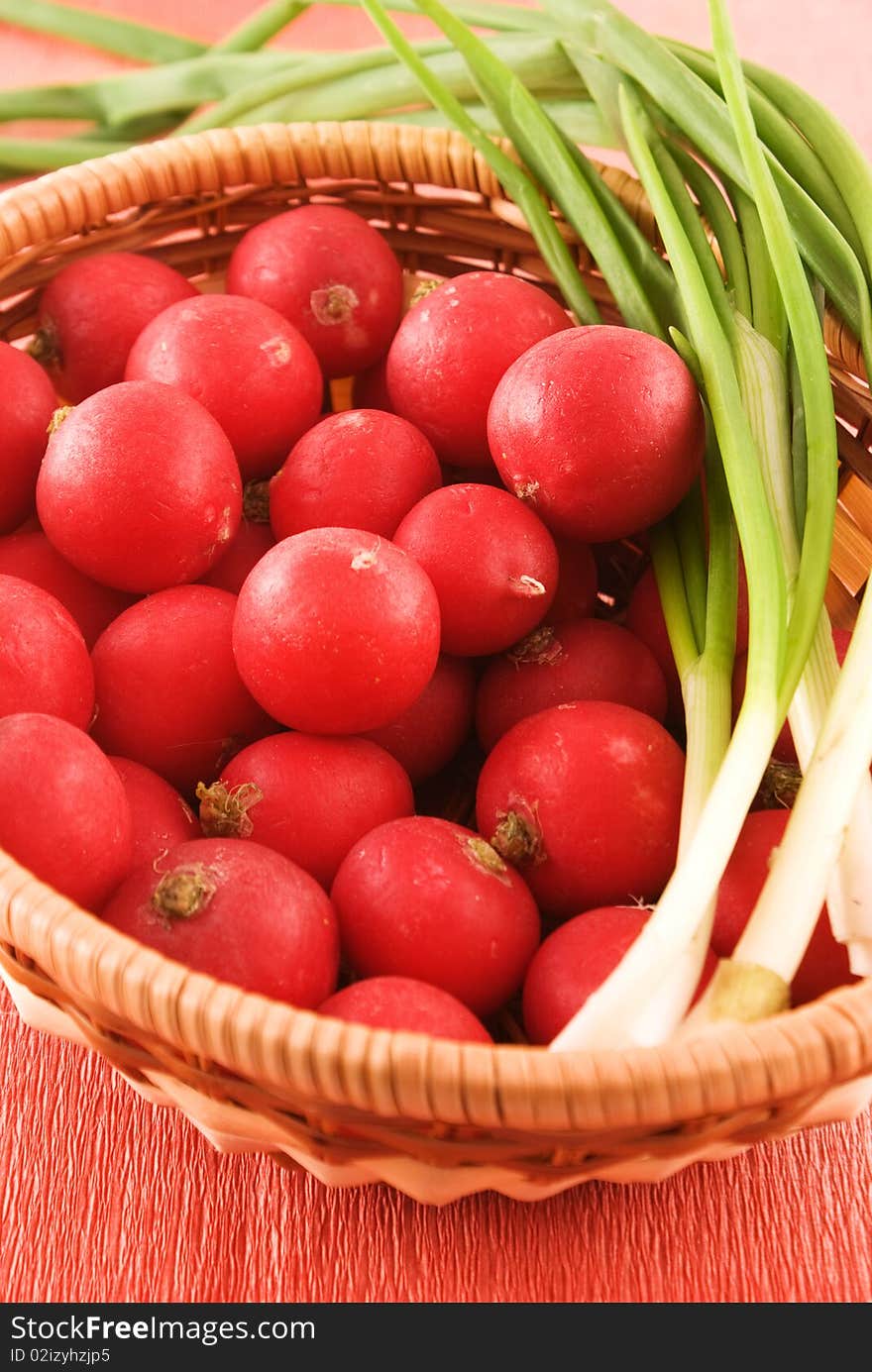 Full wicker basket with radish and onion