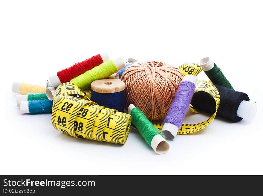 Colorful thread with yellow measuring tape isolated on white. Colorful thread with yellow measuring tape isolated on white