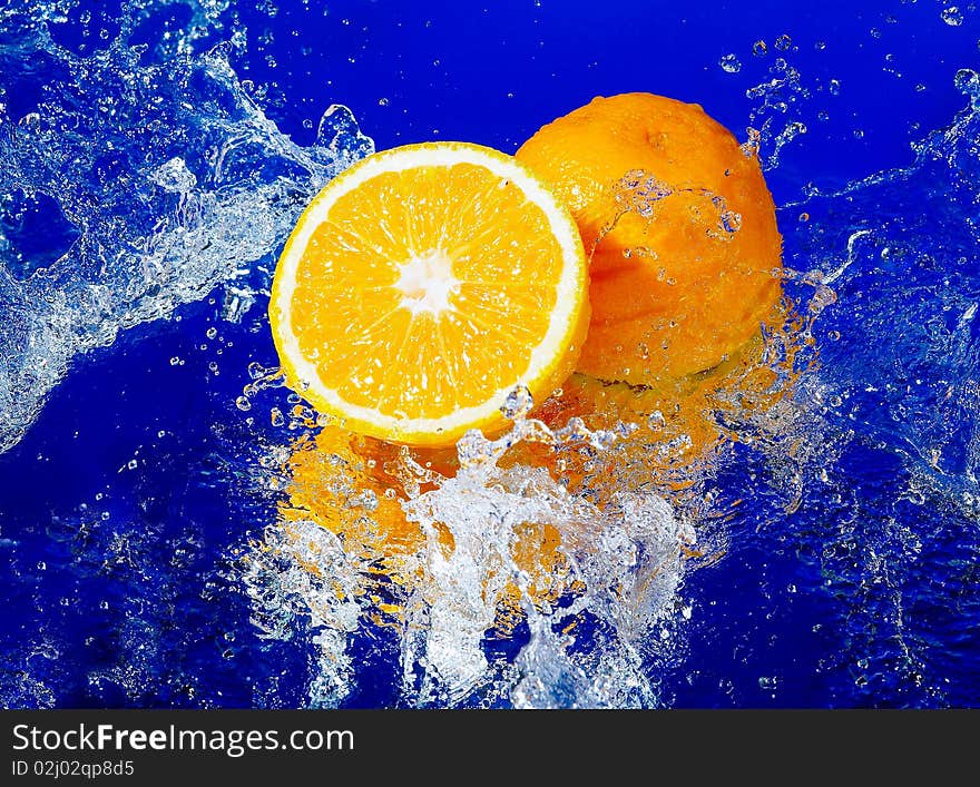 Fresh orange in a spray on a blue background