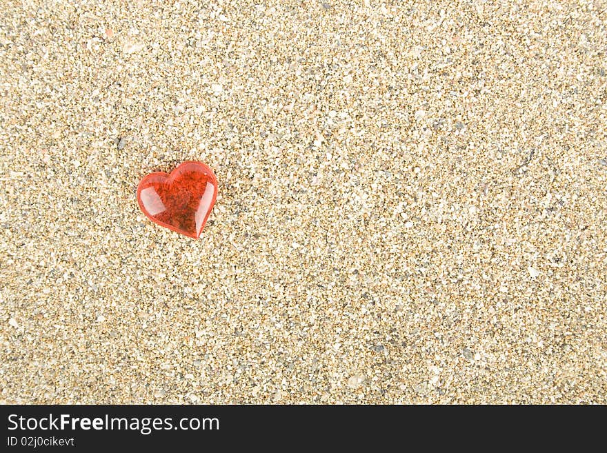 Red heart on the sand. Background. Red heart on the sand. Background