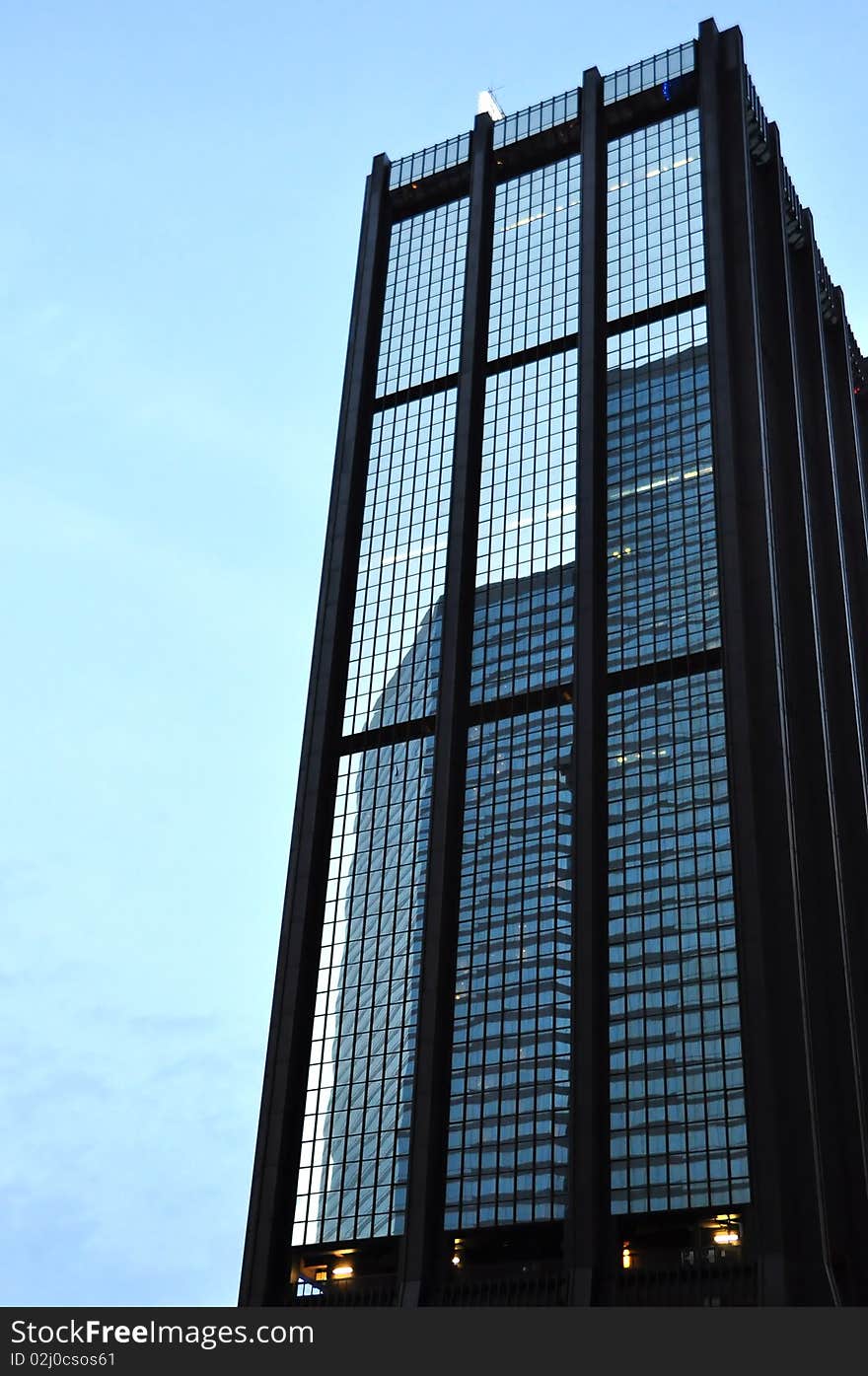 A building reflected in the windows of another building. A building reflected in the windows of another building.