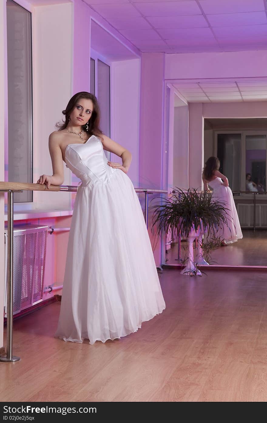 Girl in white wedding dress in dance studio. Girl in white wedding dress in dance studio