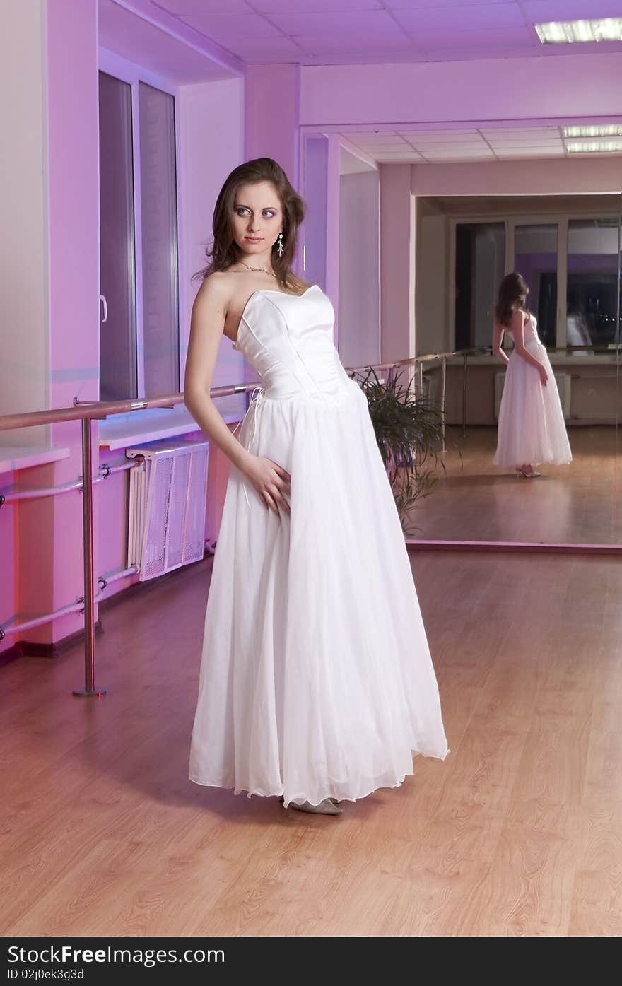 Girl in white wedding dress in dance studio. Girl in white wedding dress in dance studio