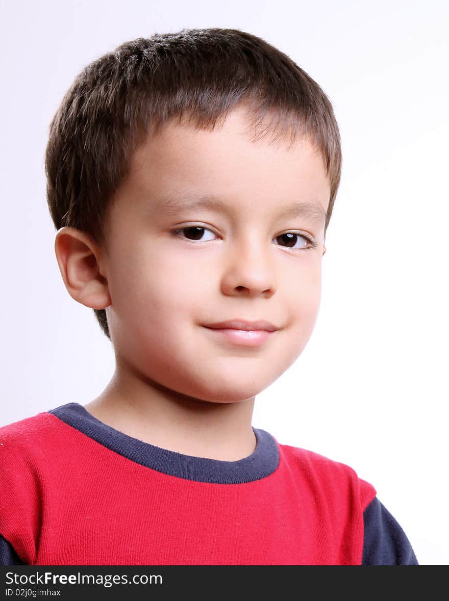 Smiling boy looking at camera over white background. Smiling boy looking at camera over white background