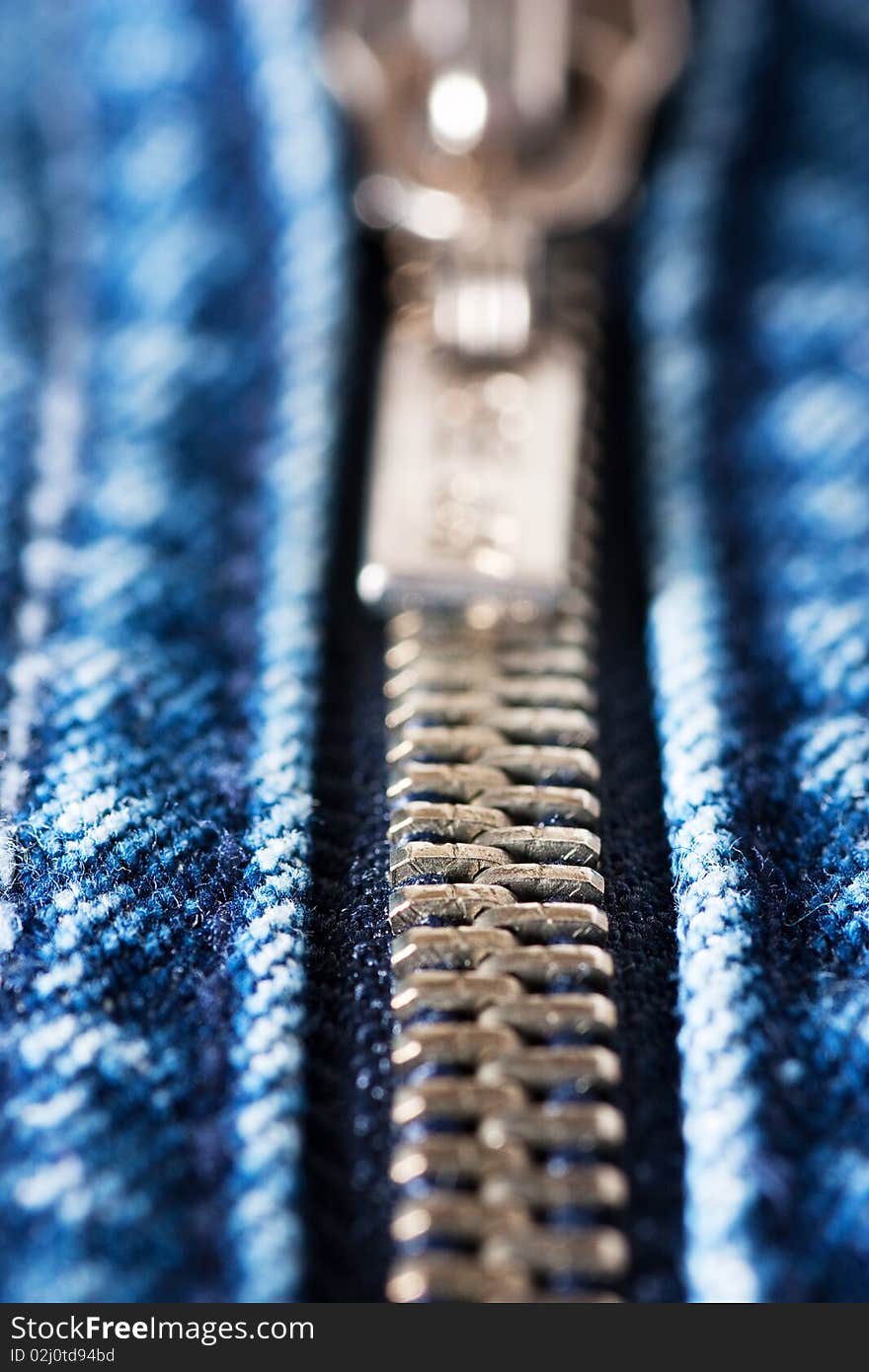 Macro shot of closed zipper on a blue jeans. Shallow depth of field