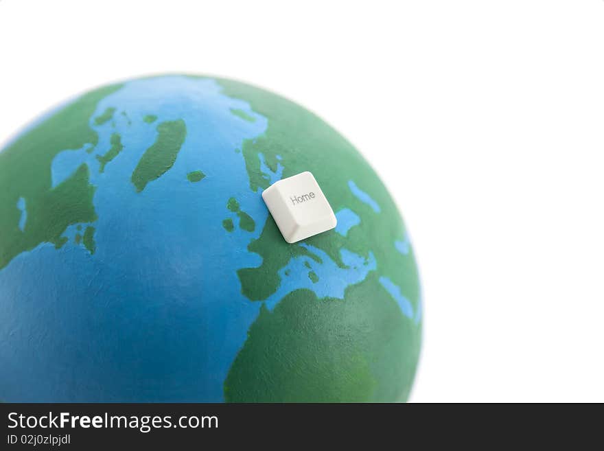 Home computer key on an earth globe isolated on white