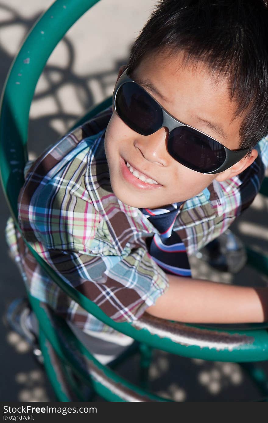 A young boy with sunglasses is smiling. A young boy with sunglasses is smiling