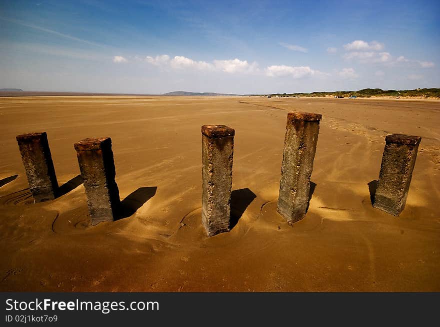 Old posts on a deserted beach. Taken with a wide angle lens and polariser filter. Old posts on a deserted beach. Taken with a wide angle lens and polariser filter.