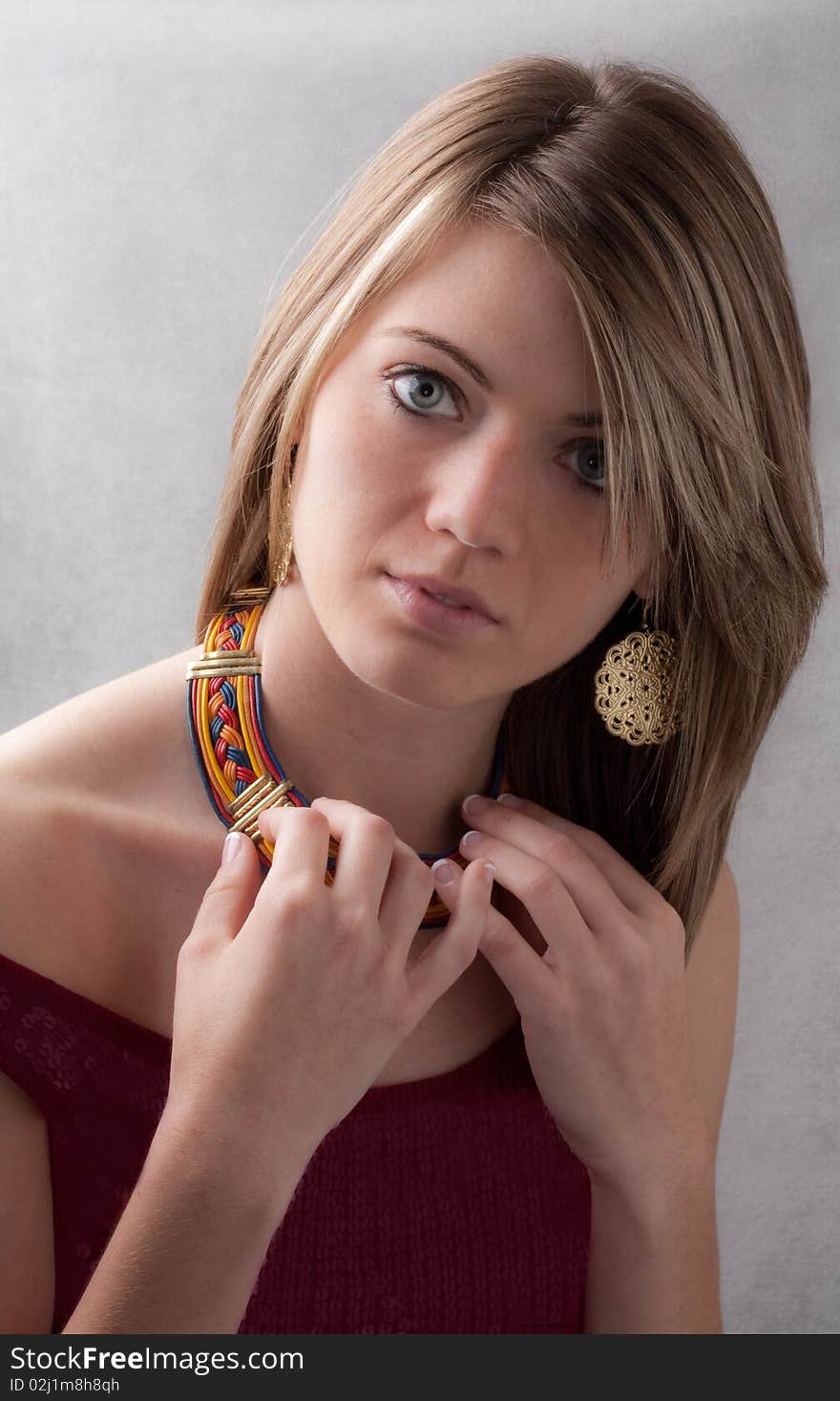 A head shot of a beautiful young woman wearing jewelry. A head shot of a beautiful young woman wearing jewelry