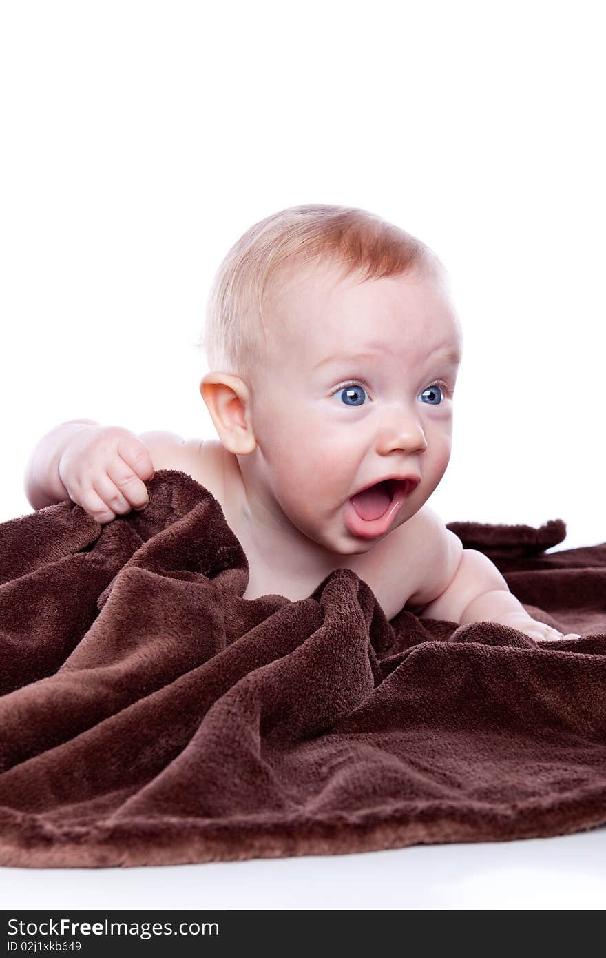 Beautiful baby under a brown towel on white background