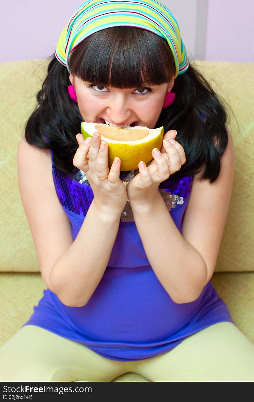 Pregnant woman eating fruits at home