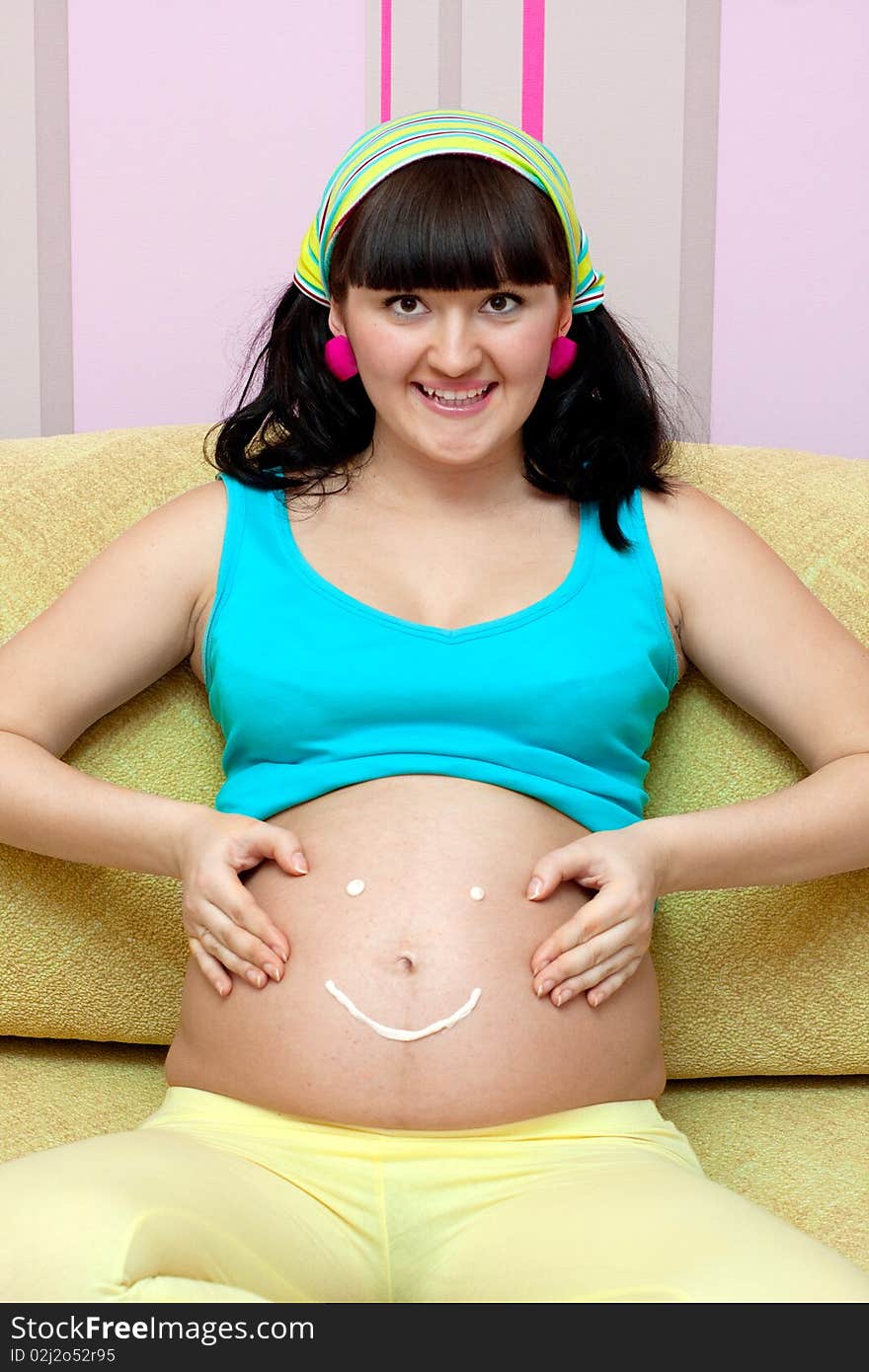 Pregnant female on yellow sofa