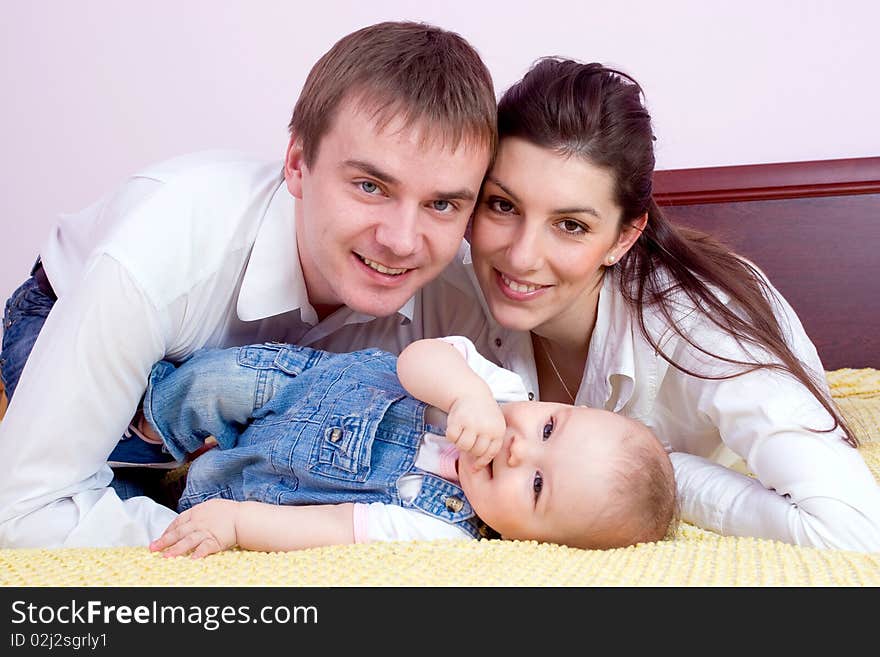 Happy family plays on the bed