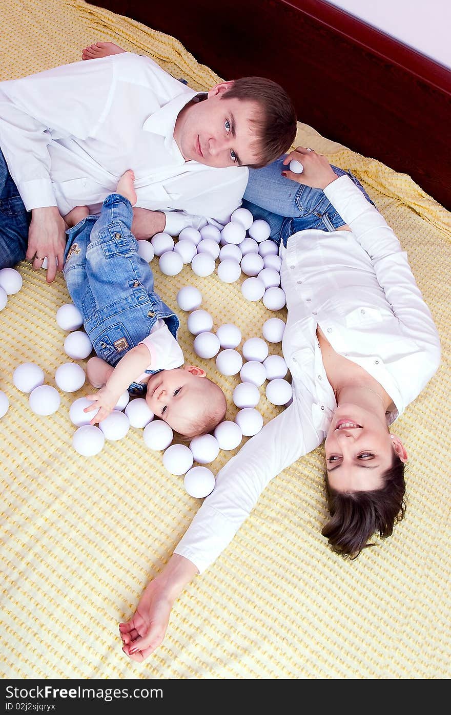 Happy family plays on the bed