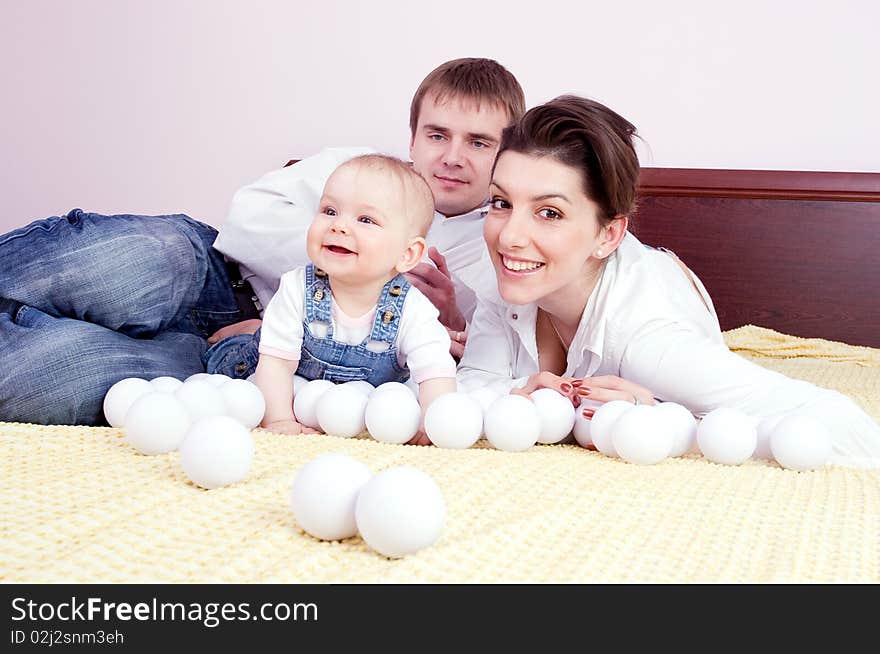 Happy family plays on the bed