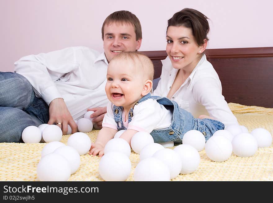 Happy family plays on the bed