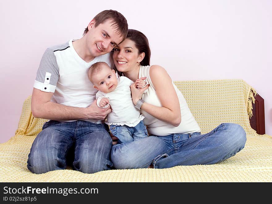 Happy family plays on the bed