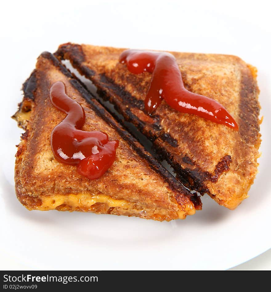 Toasted sandwich with cheese decorated with ketchup on a plate