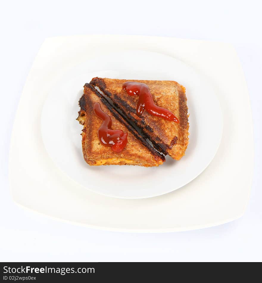 Toasted sandwich with cheese decorated with ketchup on a plate