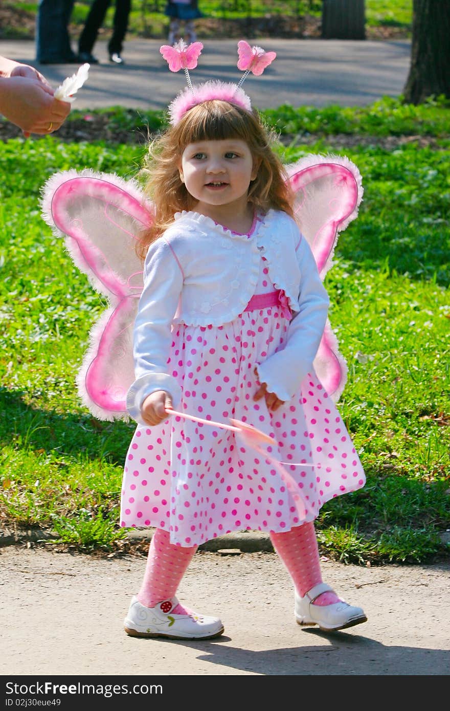 Young girl with wings in park