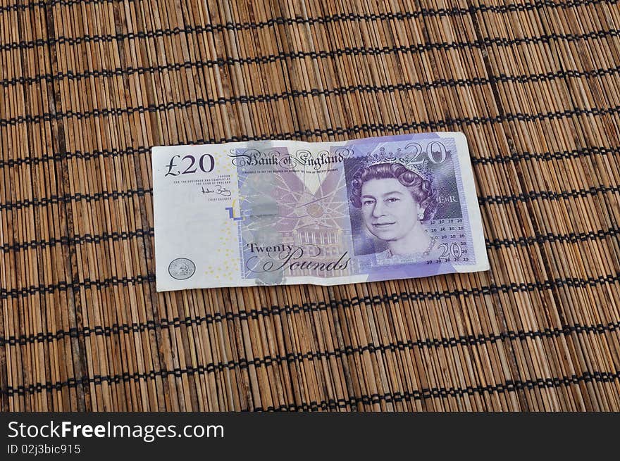 Twenty pounds (British currency) on bamboo background