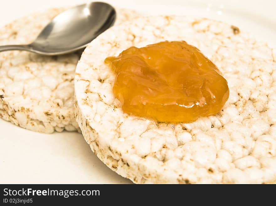 Rice biscuits with apricot jam and a spoon