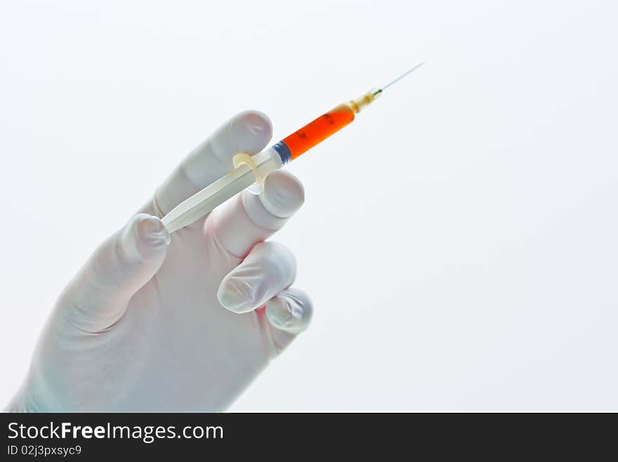 Hand holding a syringe filled with red liquid or blood isolated on white background