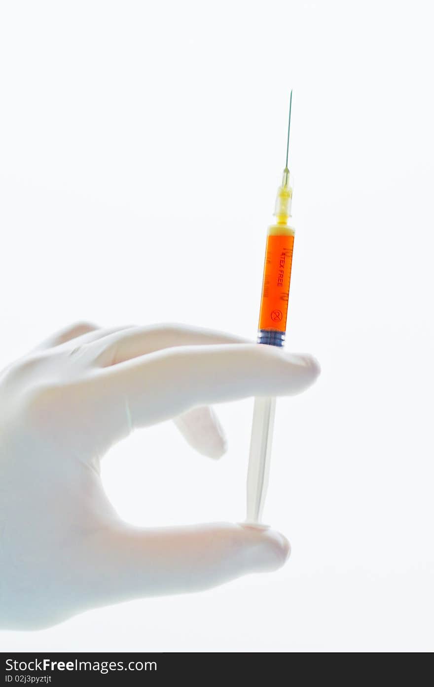 Hand holding a syringe filled with red liquid or blood isolated on white background