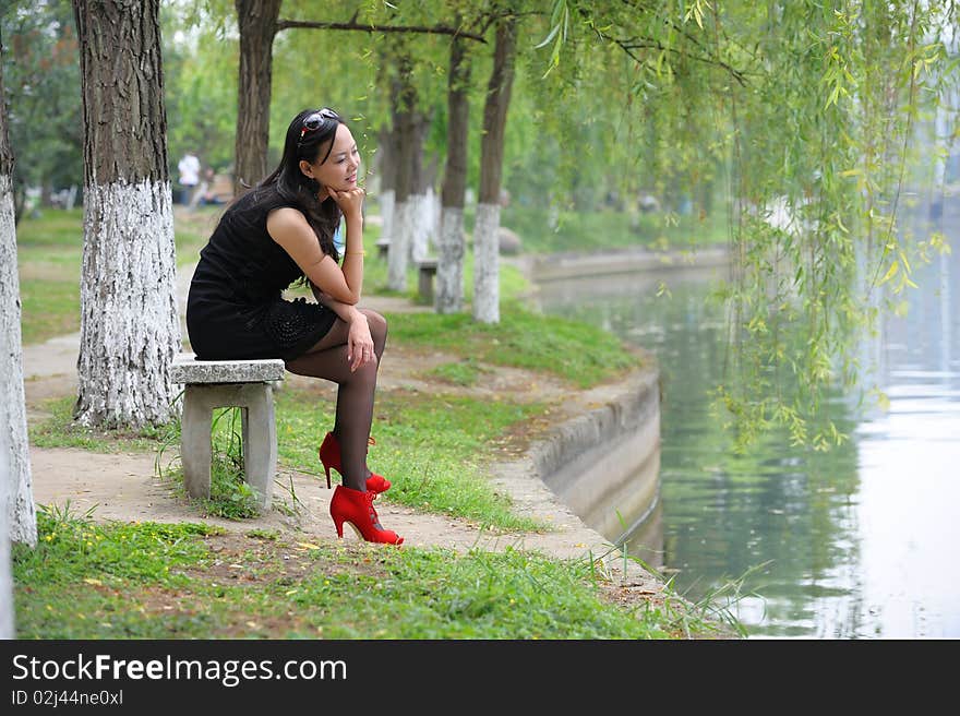 Asian woman sit in Chair with  High-heeled shoes.