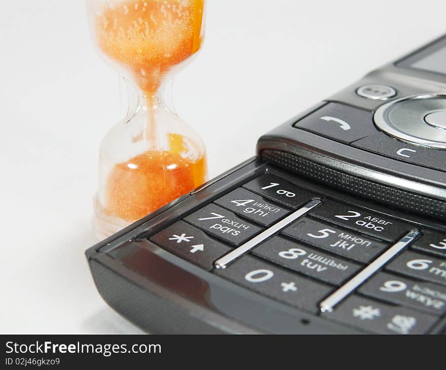 Hourglass and telephone on white background