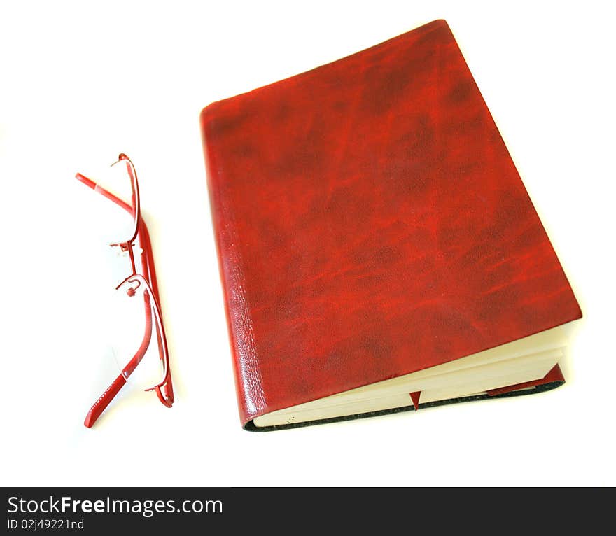 Notebook made of a red skin and glasses