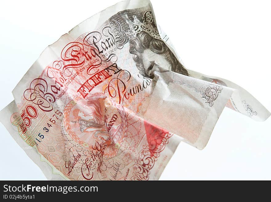 A crumpled British fifty pound note against a white background. A crumpled British fifty pound note against a white background