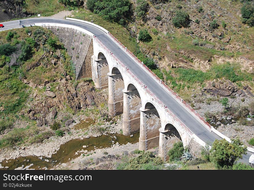 Old stone arches bridge on a countryside road. Old stone arches bridge on a countryside road