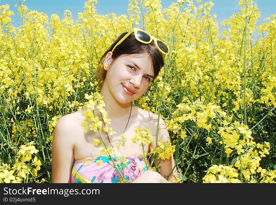 Young beautiful girl enjoying a sunny day on rapeseed flower field. Young beautiful girl enjoying a sunny day on rapeseed flower field