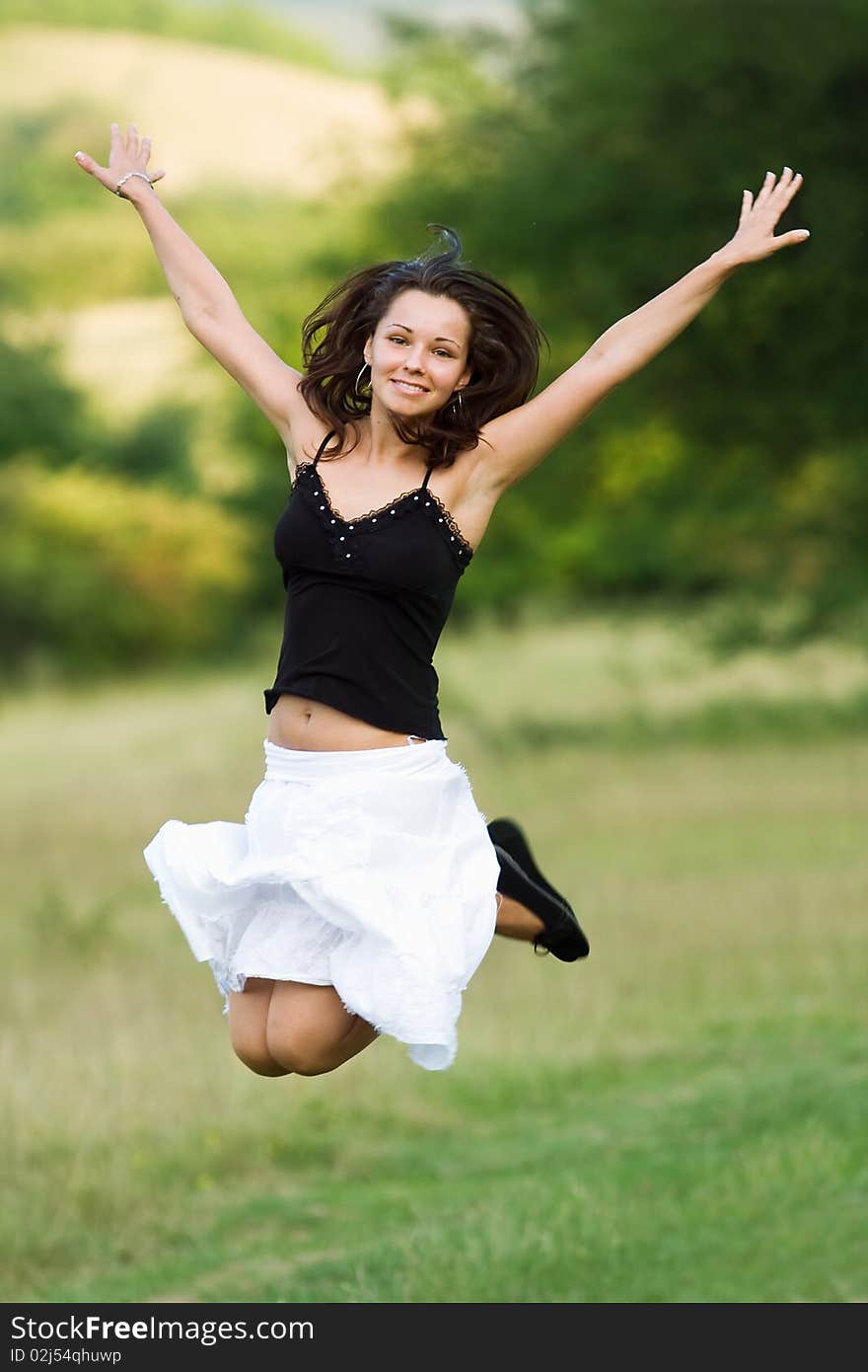 Jumping girl in green meadow