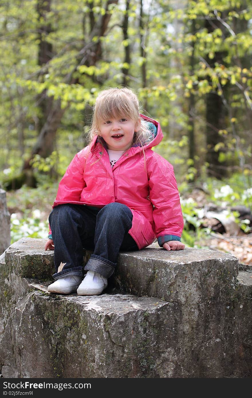 Happy Little Girl Sitting on Rock