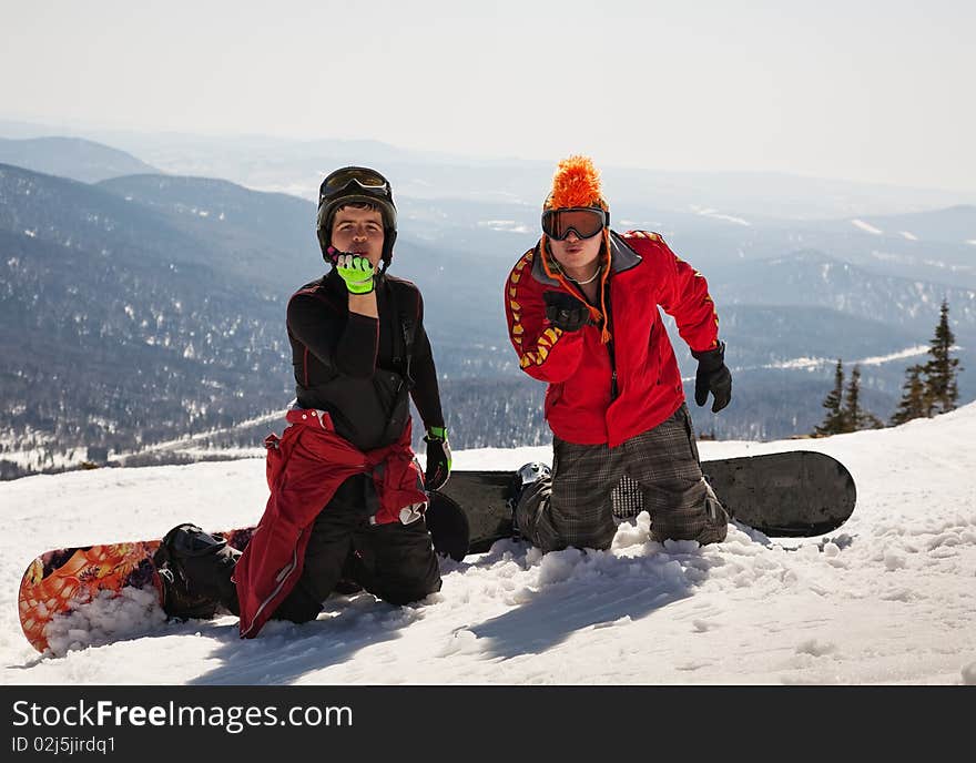 Two snowboarder blow a kiss