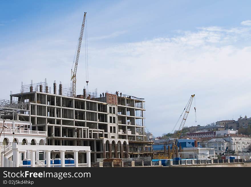 Crane near building on Cloudy sky background