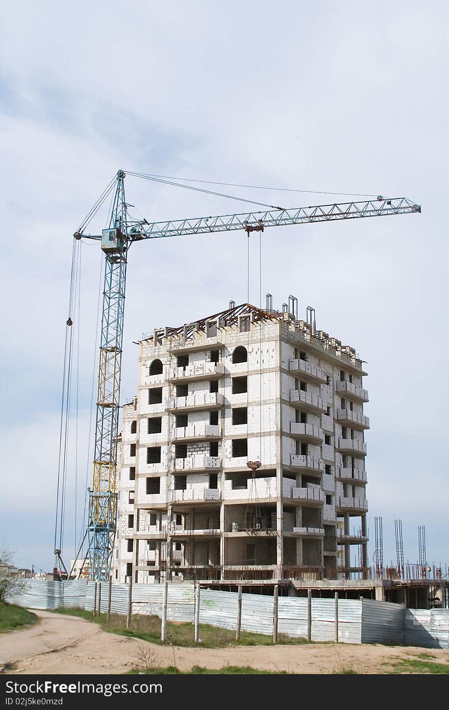 Crane near building on Cloudy sky background