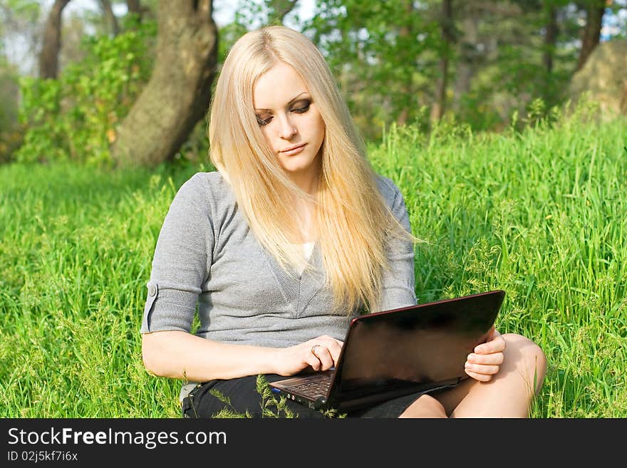 Series. The beautiful business woman with the laptop has a rest in the field